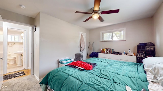 bedroom with carpet floors, baseboards, a ceiling fan, and ensuite bathroom