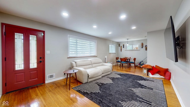 living area featuring hardwood / wood-style floors, baseboards, and recessed lighting