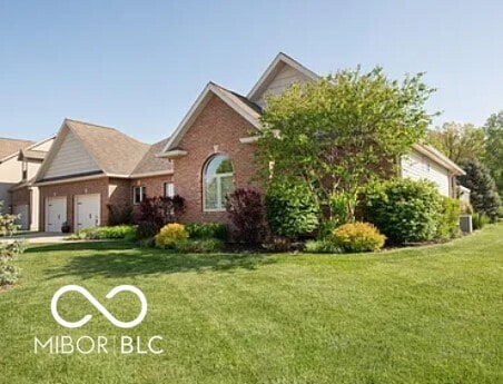 view of front of house with a front yard, a garage, and brick siding