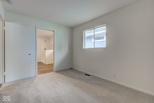 4956 W 11th St, Speedway, IN 46224 - unfurnished bedroom featuring light colored carpet, baseboards, and ensuite bathroom