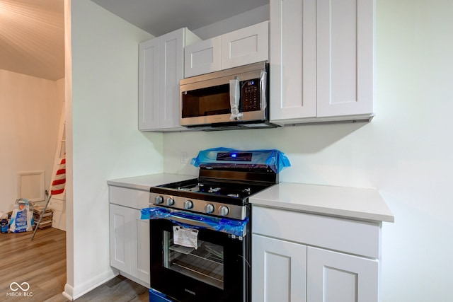 4956 W 11th St, Speedway, IN 46224 - kitchen featuring stainless steel appliances, light wood-style flooring, light countertops, and white cabinetry