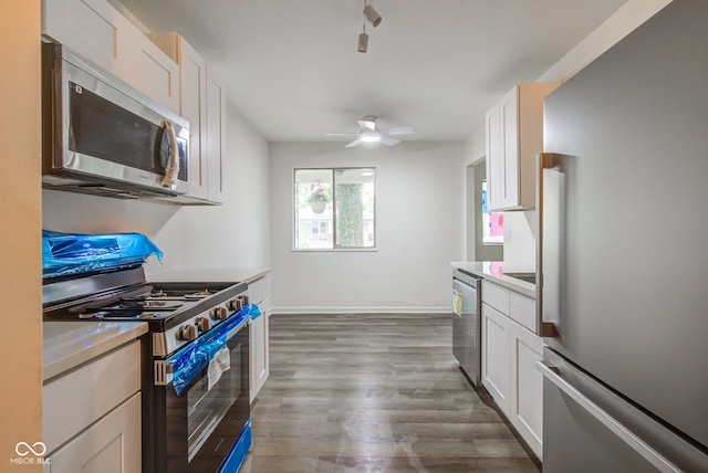 4956 W 11th St, Speedway, IN 46224 - kitchen with appliances with stainless steel finishes, white cabinetry, a ceiling fan, wood finished floors, and light countertops