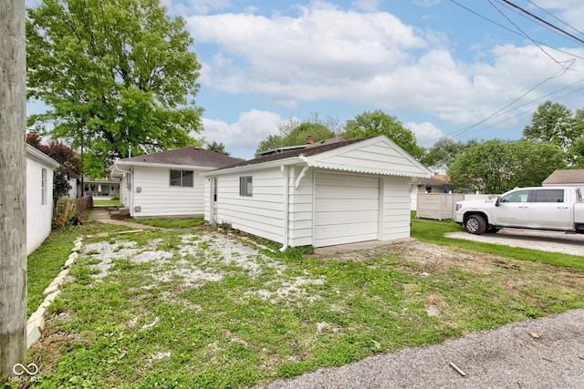 4956 W 11th St, Speedway, IN 46224 - rear view of property with an outbuilding, a garage, and a yard