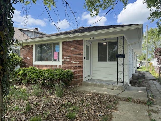 4956 W 11th St, Speedway, IN 46224 - view of exterior entry featuring brick siding and a shingled roof