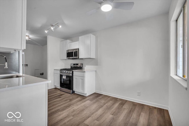 4956 W 11th St, Speedway, IN 46224 - kitchen featuring appliances with stainless steel finishes, wood finished floors, and white cabinetry