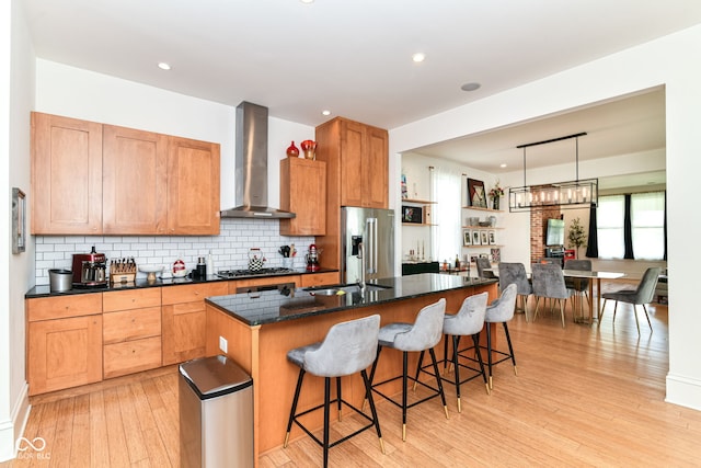 1630 N New Jersey St, Indianapolis, IN 46202 - kitchen featuring wall chimney exhaust hood, stainless steel appliances, light wood-style flooring, a center island, and backsplash