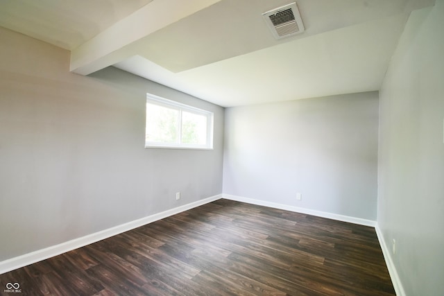 empty room featuring baseboards and dark wood-type flooring