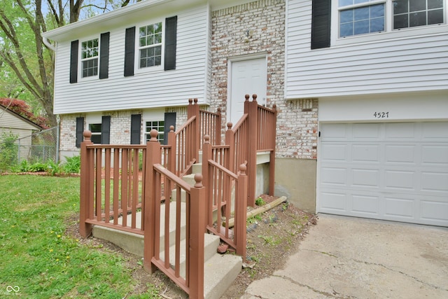 wooden terrace featuring an attached garage, driveway, and fence