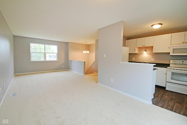 kitchen featuring white appliances, dark colored carpet, baseboards, and white cabinetry
