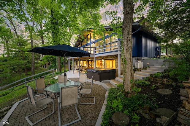 7753 Ivy Dr, Nineveh, IN 46164 - rear view of property featuring a hot tub, a patio area, a wooden deck, board and batten siding, and outdoor dining space