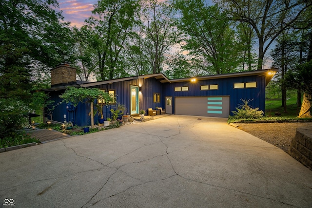 7753 Ivy Dr, Nineveh, IN 46164 - mid-century home featuring board and batten siding, a garage, driveway, and a chimney