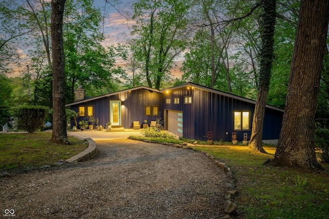 7753 Ivy Dr, Nineveh, IN 46164 - mid-century modern home with board and batten siding, a garage, driveway, and a chimney