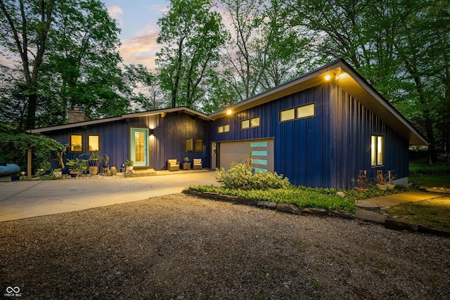 7753 Ivy Dr, Nineveh, IN 46164 - mid-century home with board and batten siding, concrete driveway, a garage, and a chimney