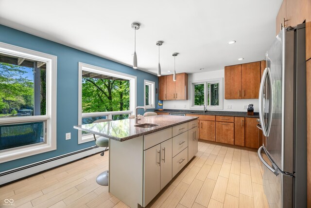 7753 Ivy Dr, Nineveh, IN 46164 - kitchen featuring freestanding refrigerator, baseboard heating, a sink, brown cabinets, and recessed lighting