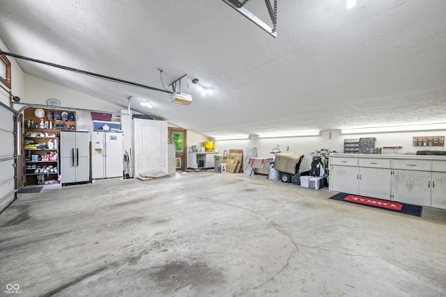 7753 Ivy Dr, Nineveh, IN 46164 - garage with white refrigerator and a garage door opener
