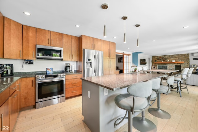 7753 Ivy Dr, Nineveh, IN 46164 - kitchen with appliances with stainless steel finishes, open floor plan, a kitchen breakfast bar, brown cabinetry, and recessed lighting