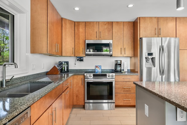 7753 Ivy Dr, Nineveh, IN 46164 - kitchen featuring stainless steel appliances, a sink, dark stone counters, brown cabinetry, and recessed lighting