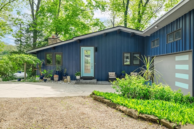 7753 Ivy Dr, Nineveh, IN 46164 - view of side of property featuring board and batten siding, a chimney, and concrete driveway