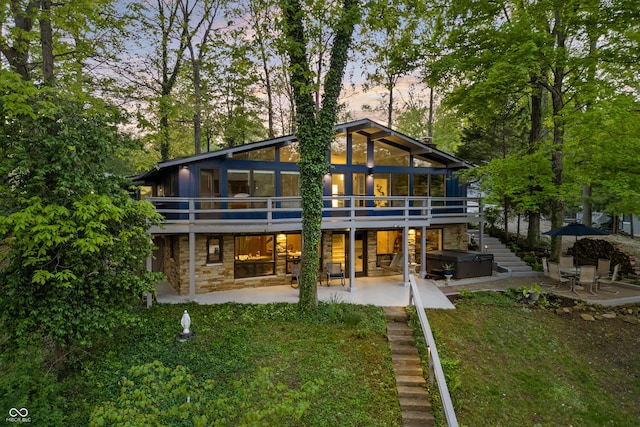 7753 Ivy Dr, Nineveh, IN 46164 - back of house at dusk with stone siding, a patio, a deck, and stairway