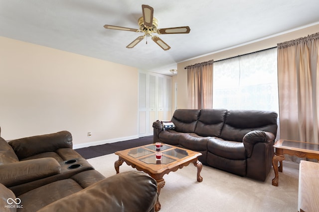 carpeted living area with a ceiling fan and baseboards