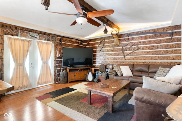 living room with ceiling fan, beamed ceiling, and wood finished floors