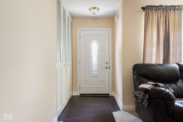 entryway featuring baseboards and dark wood finished floors