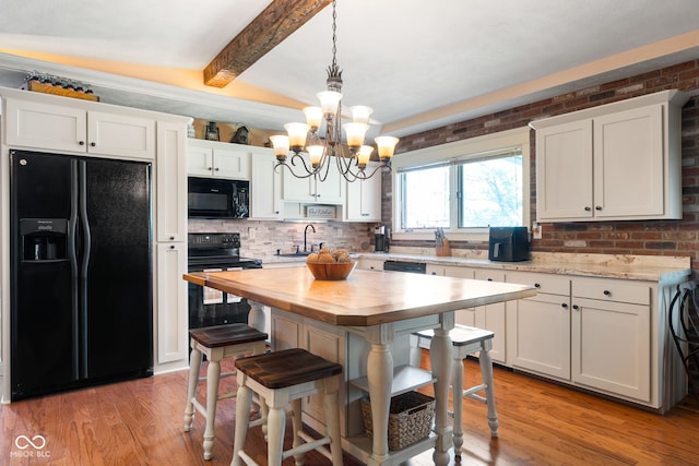 kitchen featuring black appliances, butcher block countertops, a sink, decorative backsplash, and white cabinets