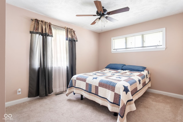 bedroom featuring light carpet, baseboards, and ceiling fan