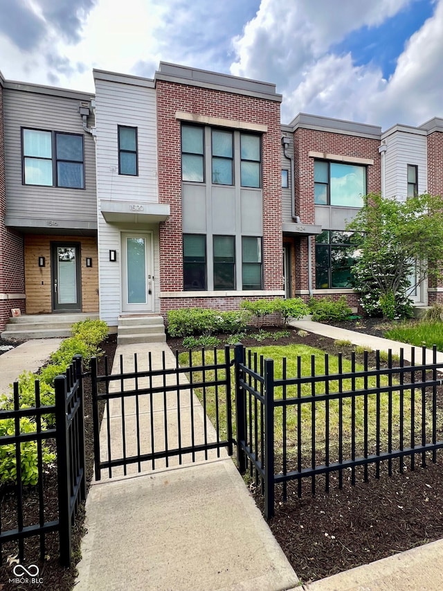 view of front of property featuring brick siding and a gate