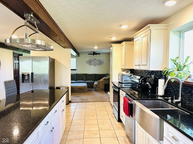 3081 Woodridge Rd, Shelbyville, IN 46176 - kitchen with appliances with stainless steel finishes, healthy amount of natural light, light colored carpet, a sink, and a textured ceiling