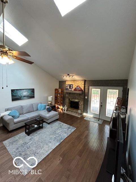 209 Brighton Ct, Greenwood, IN 46143 - living room with lofted ceiling, a ceiling fan, dark wood-style flooring, french doors, and a stone fireplace