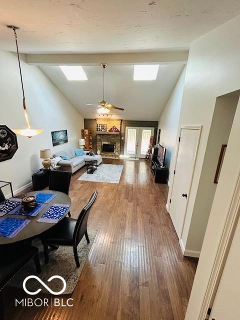 209 Brighton Ct, Greenwood, IN 46143 - dining room featuring a fireplace, ceiling fan, dark wood-style floors, and baseboards