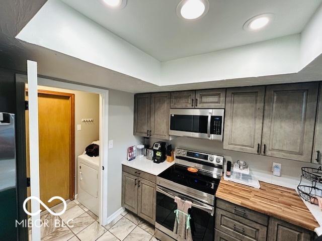 209 Brighton Ct, Greenwood, IN 46143 - kitchen featuring stainless steel appliances, washer / dryer, and wooden counters