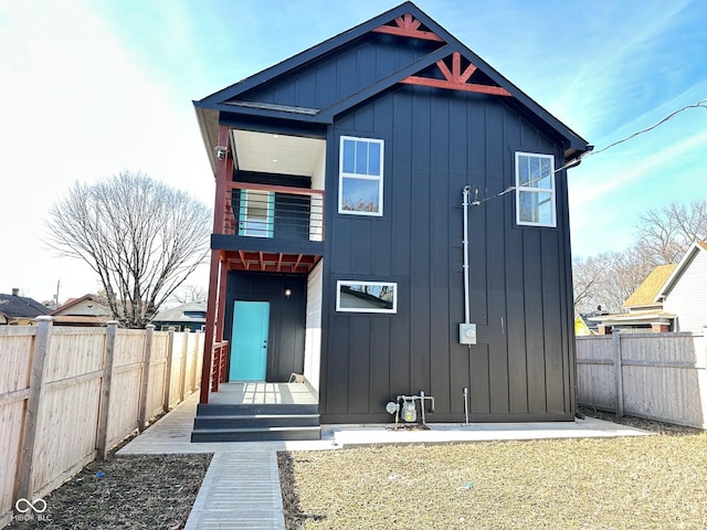 337 N Beville Ave, Indianapolis, IN 46201 - view of front of property with board and batten siding, a balcony, and a fenced backyard