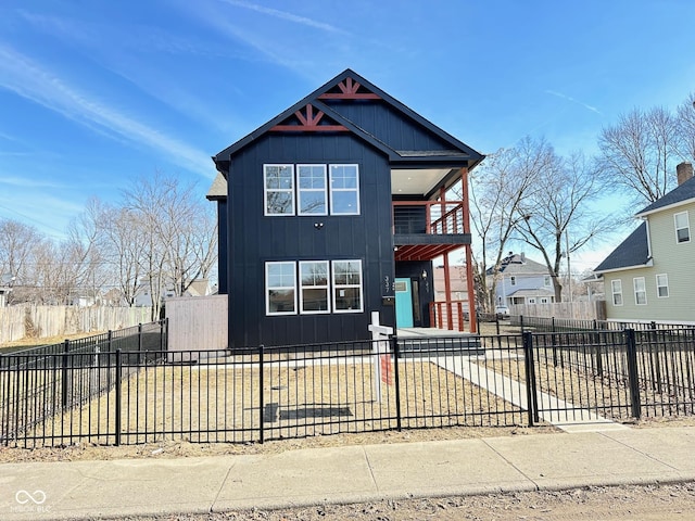 337 N Beville Ave, Indianapolis, IN 46201 - view of front facade featuring board and batten siding, a fenced front yard, and a balcony