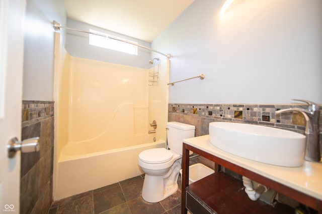 bathroom with tile walls, toilet, wainscoting, shower / bath combination, and vanity