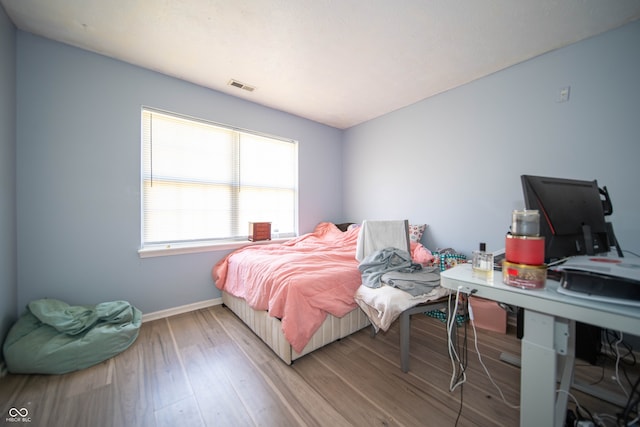 bedroom featuring baseboards and wood finished floors