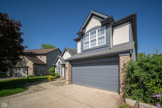 traditional-style house with brick siding, a garage, driveway, and a shingled roof