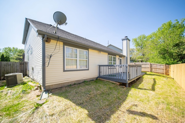 back of house featuring central air condition unit, a wooden deck, and a chimney