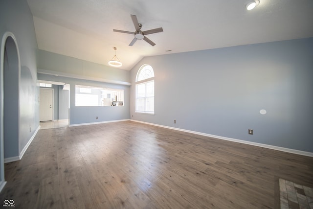 spare room featuring a ceiling fan, lofted ceiling, wood finished floors, and baseboards