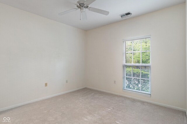 unfurnished room with light colored carpet, baseboards, and ceiling fan
