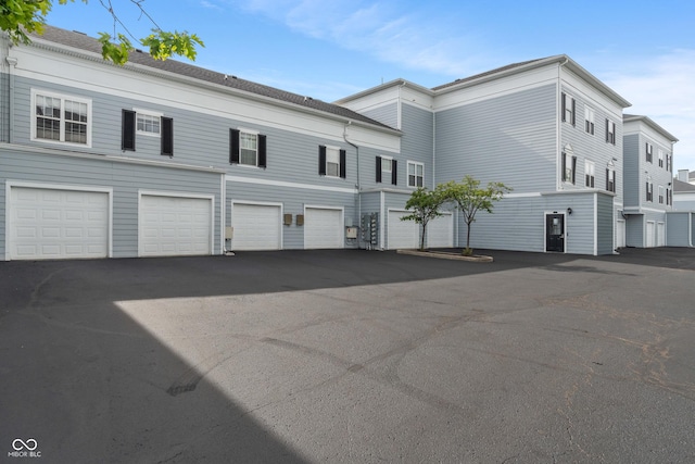 view of property with asphalt driveway