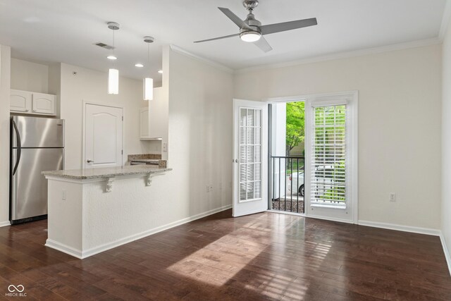 kitchen with freestanding refrigerator, dark wood-style floors, a peninsula, crown molding, and light stone counters