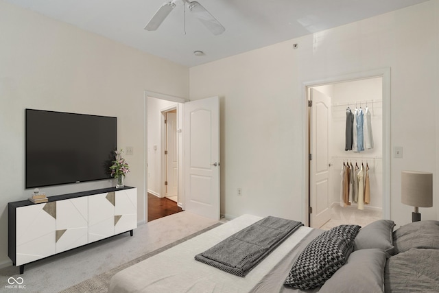 carpeted bedroom featuring ceiling fan and a spacious closet