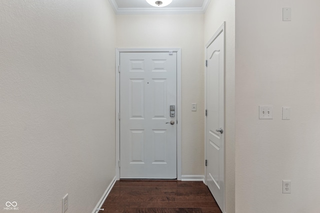 doorway with ornamental molding, dark wood finished floors, and baseboards