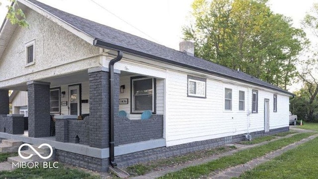 3436 Garden Ave, Indianapolis, IN 46222 - view of side of home featuring a porch, a chimney, and cooling unit