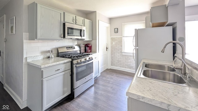 3436 Garden Ave, Indianapolis, IN 46222 - kitchen with stainless steel appliances, wood finished floors, baseboards, a sink, and light countertops