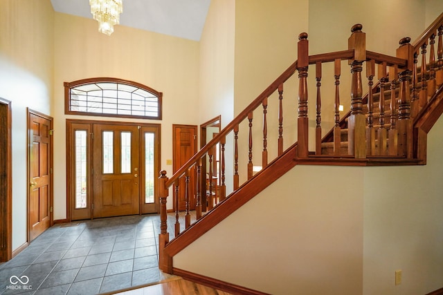 2508 Indian Creek Rd, Trafalgar, IN 46181 - tiled entrance foyer with stairway, a high ceiling, a chandelier, and baseboards
