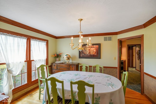 2508 Indian Creek Rd, Trafalgar, IN 46181 - dining room featuring a chandelier, healthy amount of natural light, wood finished floors, crown molding, and baseboards