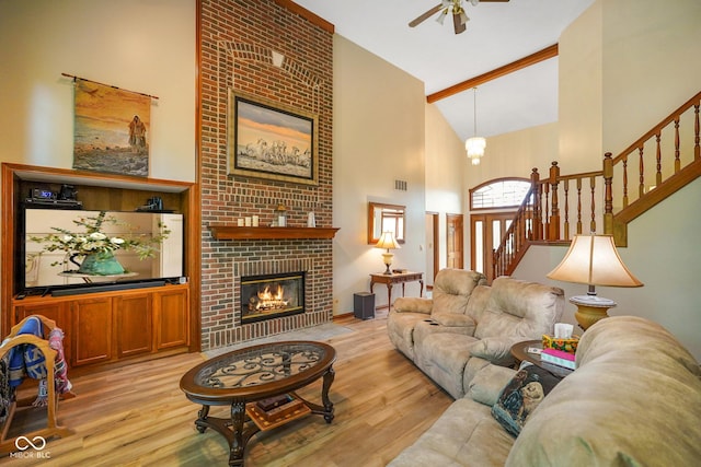 2508 Indian Creek Rd, Trafalgar, IN 46181 - living room featuring high vaulted ceiling, light wood finished floors, a ceiling fan, stairway, and a brick fireplace
